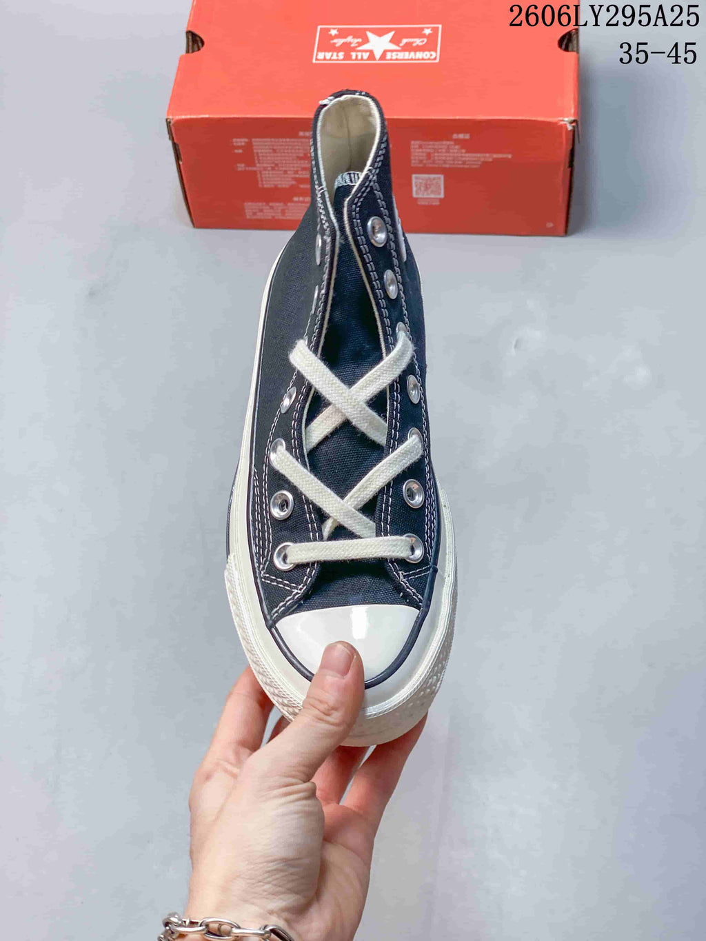 Top view of a navy Converse high-top sneaker showing the white laces, rubber toe cap, silver eyelets and contrast stitching.