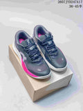 Pair of dark gray On sneakers with pink side accents displayed on a shoebox.