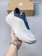 Angled side view of the white and navy slip-on sneaker with its low-top silhouette.