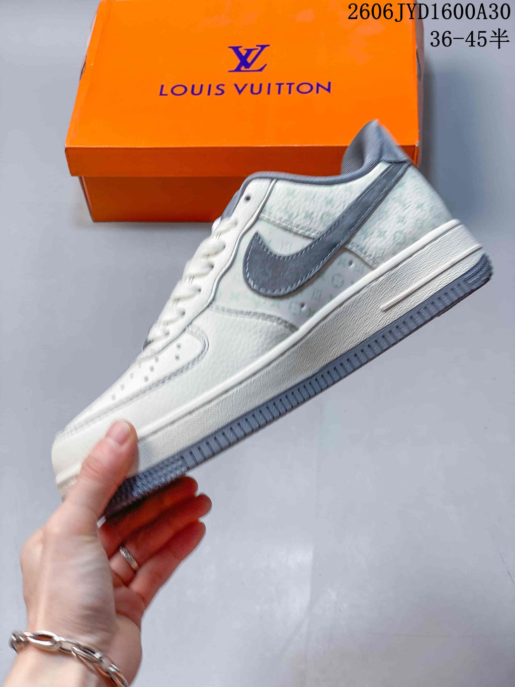 Side view of a cream low-top sneaker with gray accents and patterned panels
