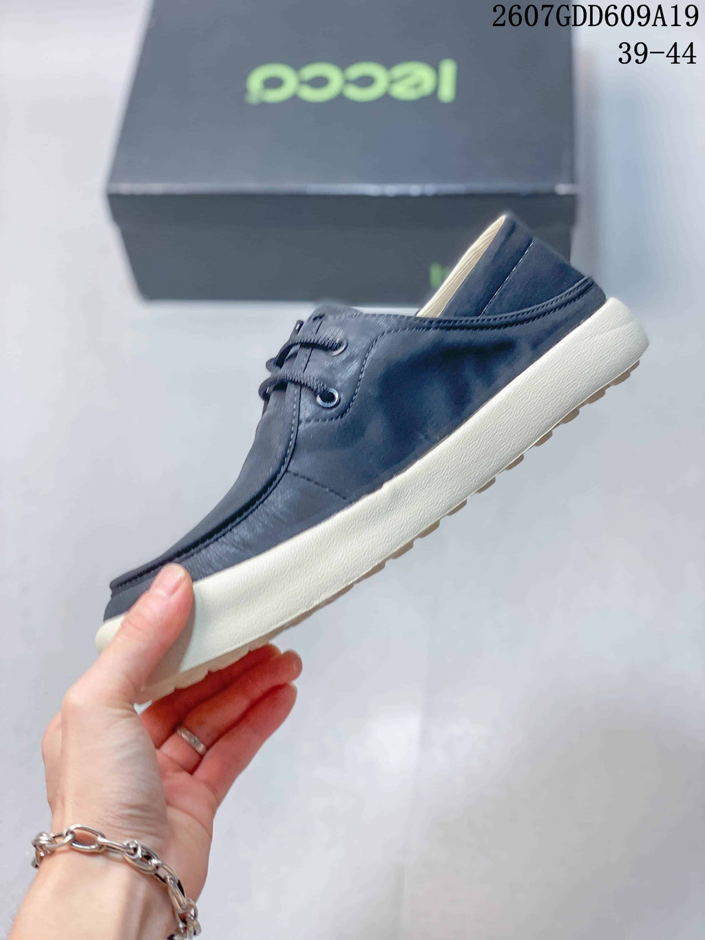Side profile of the navy low-top sneaker with lace-up front, stitched panels, and contrast off-white sole.