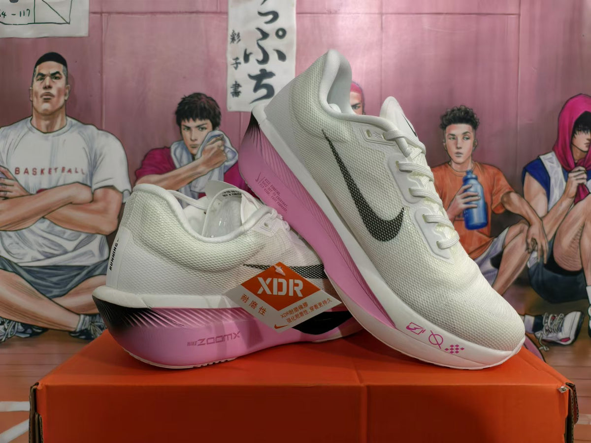 Angled view of white Nike running shoes with pink accents