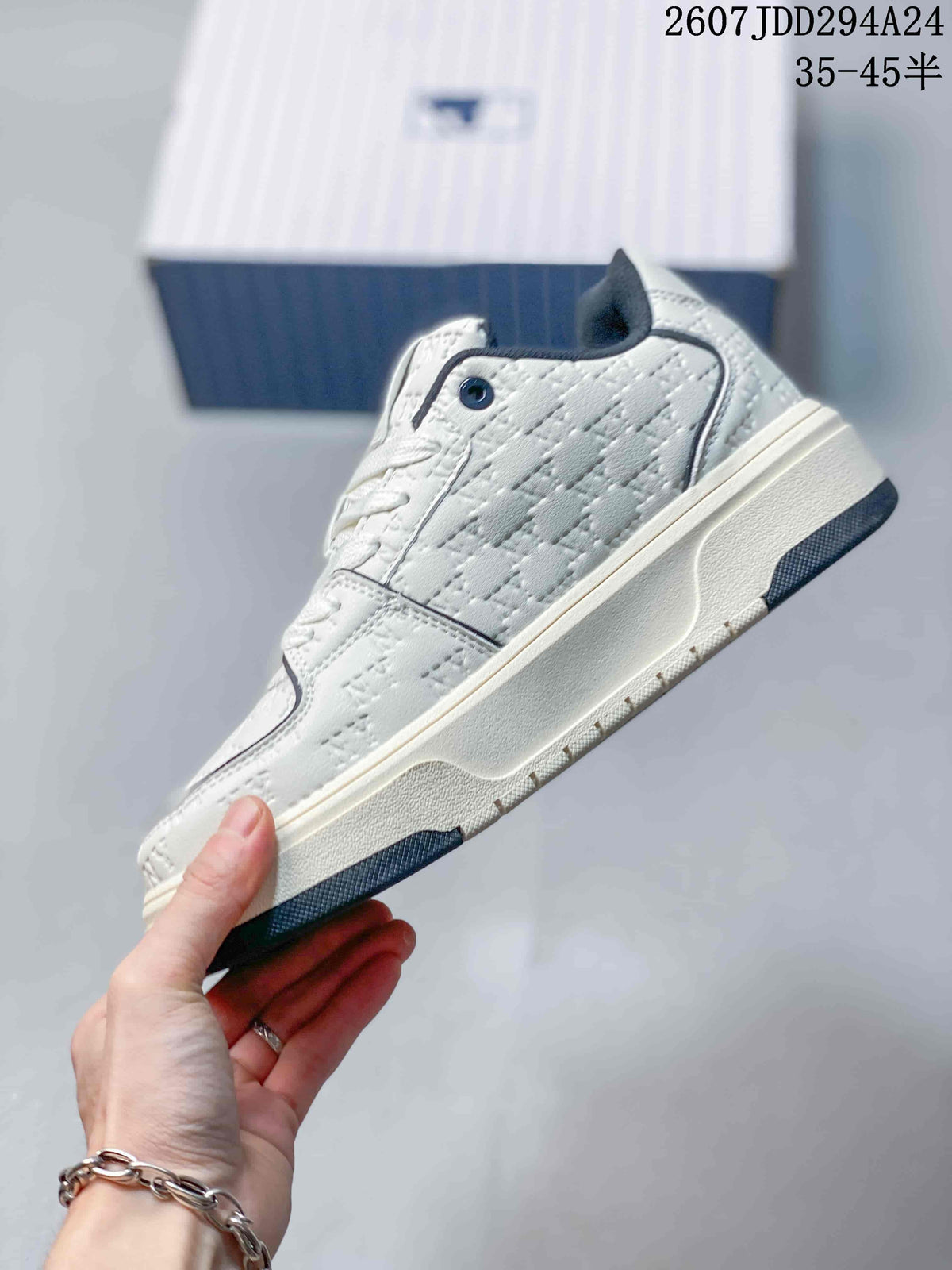 Side profile of the white and navy mid-top sneaker showing its raised sole and embossed upper pattern.