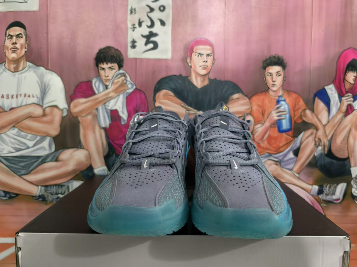 Front view of blue-gray Nike basketball shoes showing perforated uppers and teal-colored toe sections.
