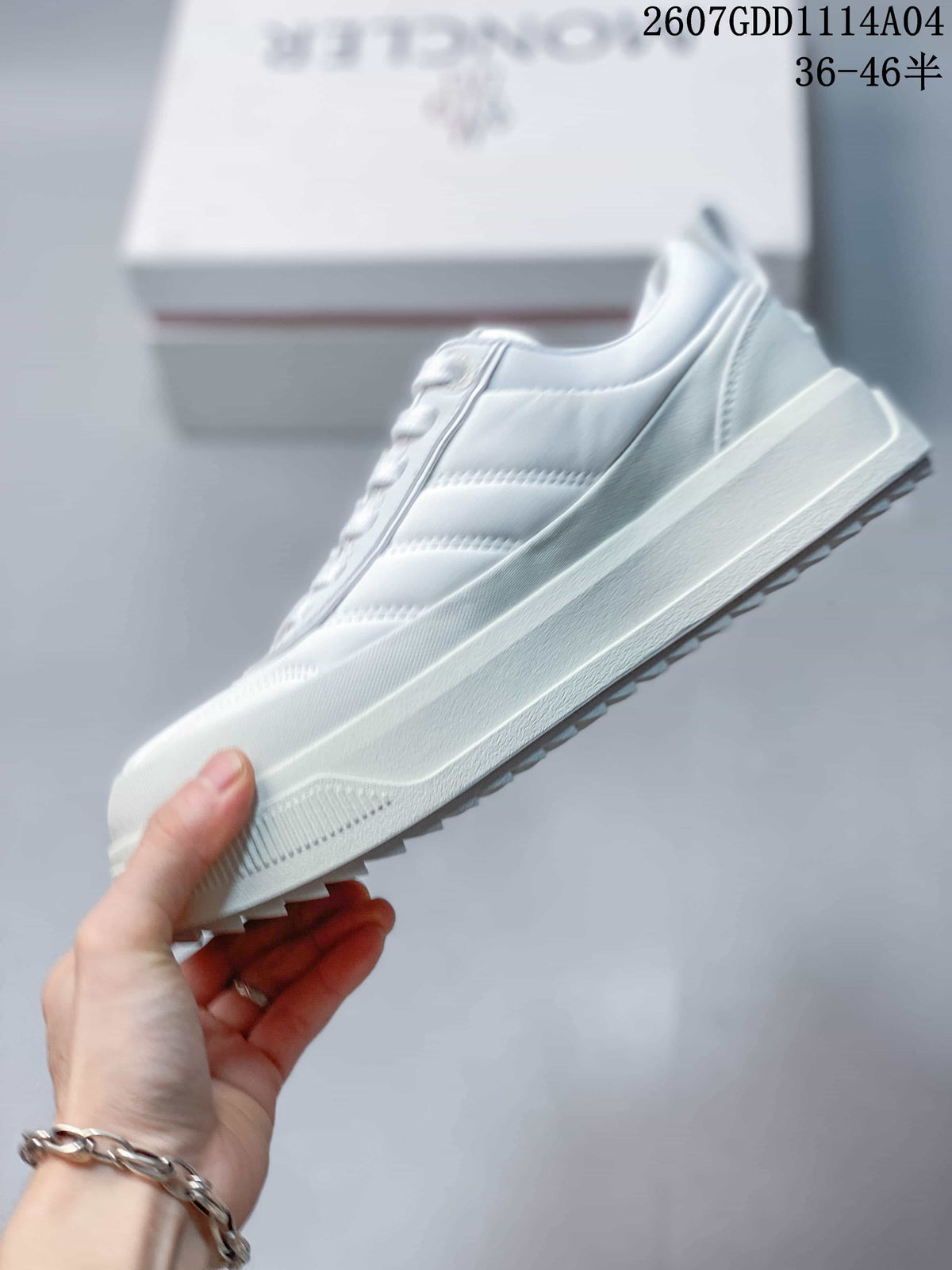 Side profile of the white lace-up sneaker showing layered panels, raised midsole and toothed outsole edge.