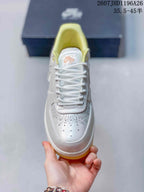 Top view of the sneaker showing white laces, the branded tongue, perforated toe box, and decorative toe detailing.