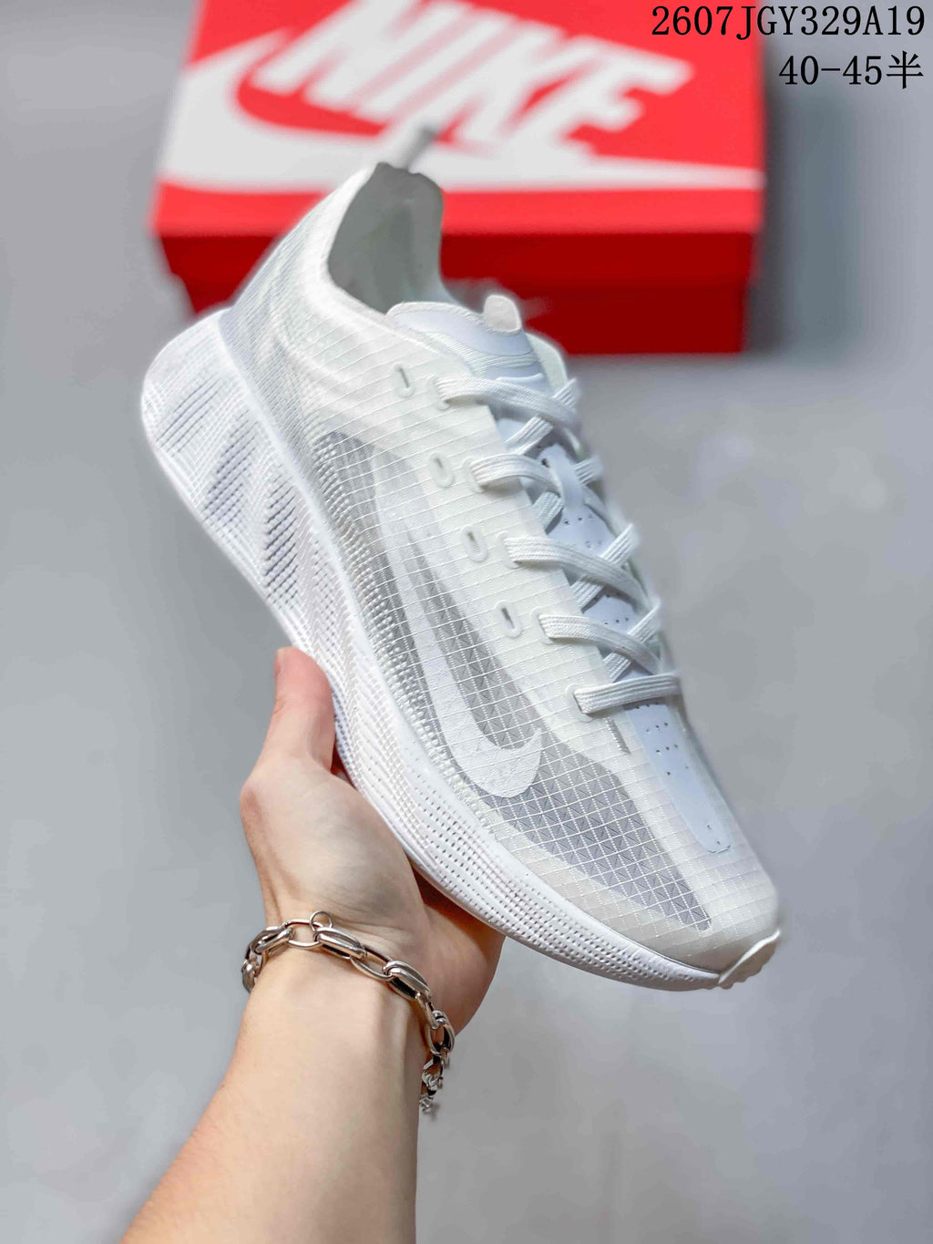 Angled side view of the white sneaker showing the lace system, translucent side panels, Nike Swoosh, and textured sole.