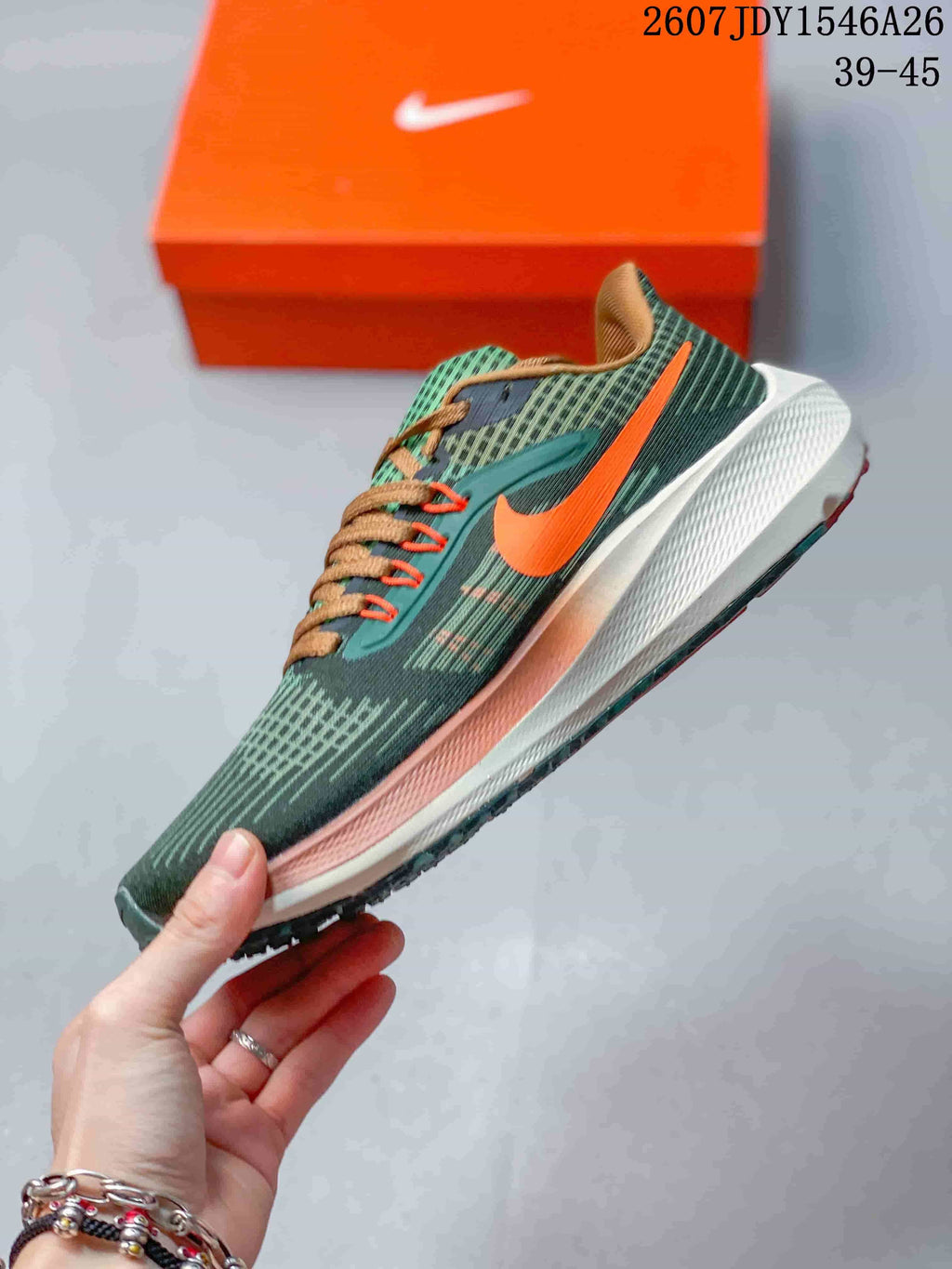 Side profile of a green Nike running shoe with an orange Swoosh, tan laces, white midsole, and textured outsole.