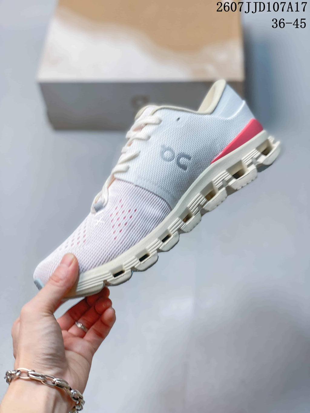 Side view of the white On sneaker showing the engineered upper, lace closure, segmented sole and red heel detail.