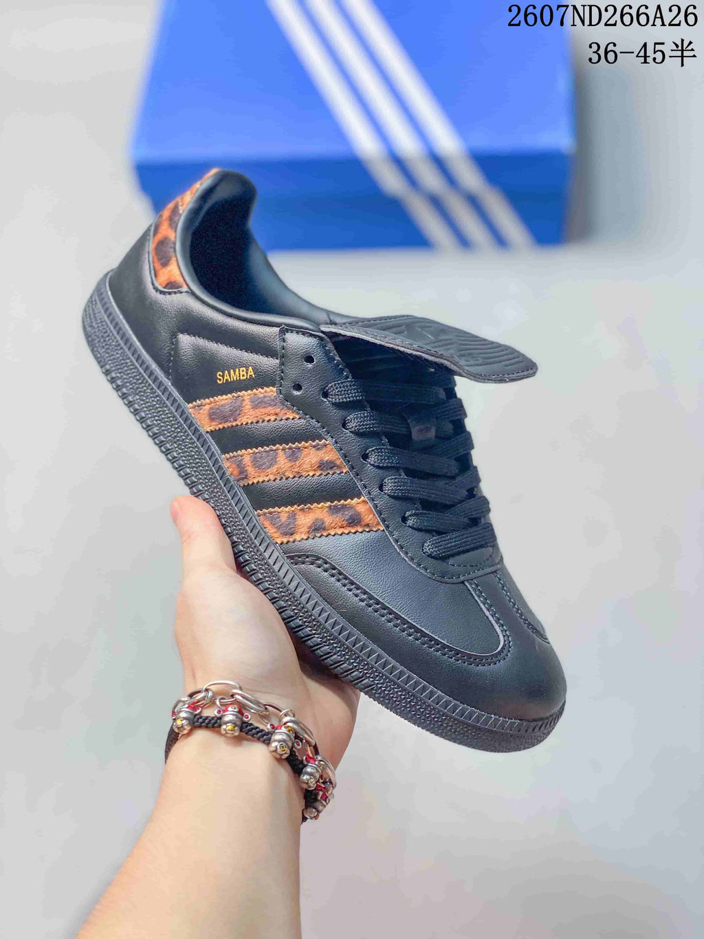 Side view of a black adidas Originals Samba sneaker showing the three-stripe panel, Samba branding, flap tongue, laces, and textured outsole.