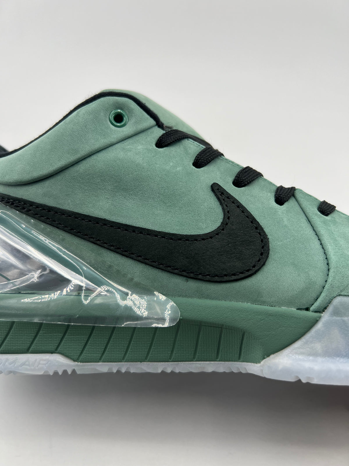 Side detail showing the black Swoosh, green upper and clear heel accent