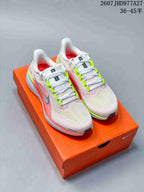 Pair of Nike Quest 6 running shoes in light pink and white with neon green accents, displayed on an orange shoe box.