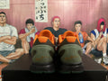 Rear view of orange basketball shoes with dark green heel panels and black midsoles