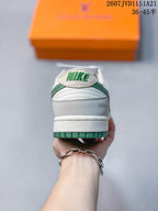 Rear view of the sneaker showing the padded heel, green outsole edge, Nike tongue detail, and visible decorative side marking.