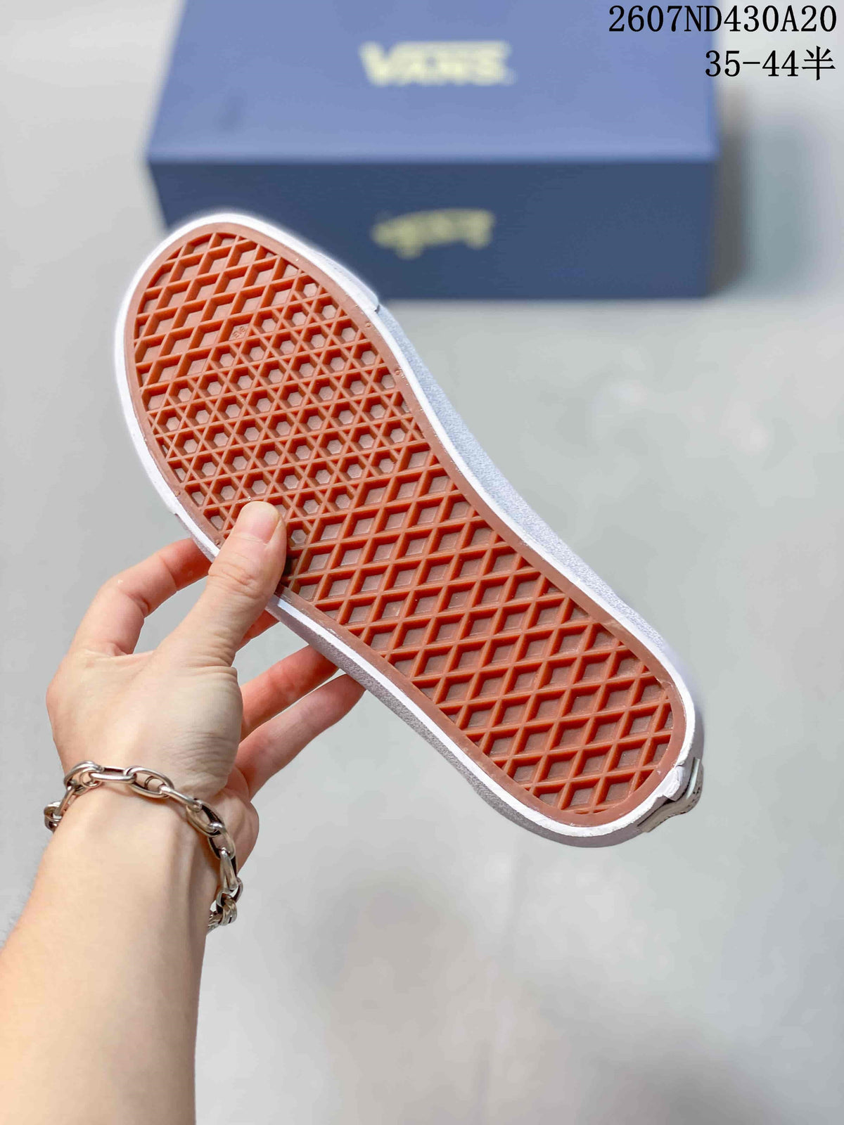 Close-up of the sneaker outsole showing a waffle-pattern tread in orange-brown rubber.
