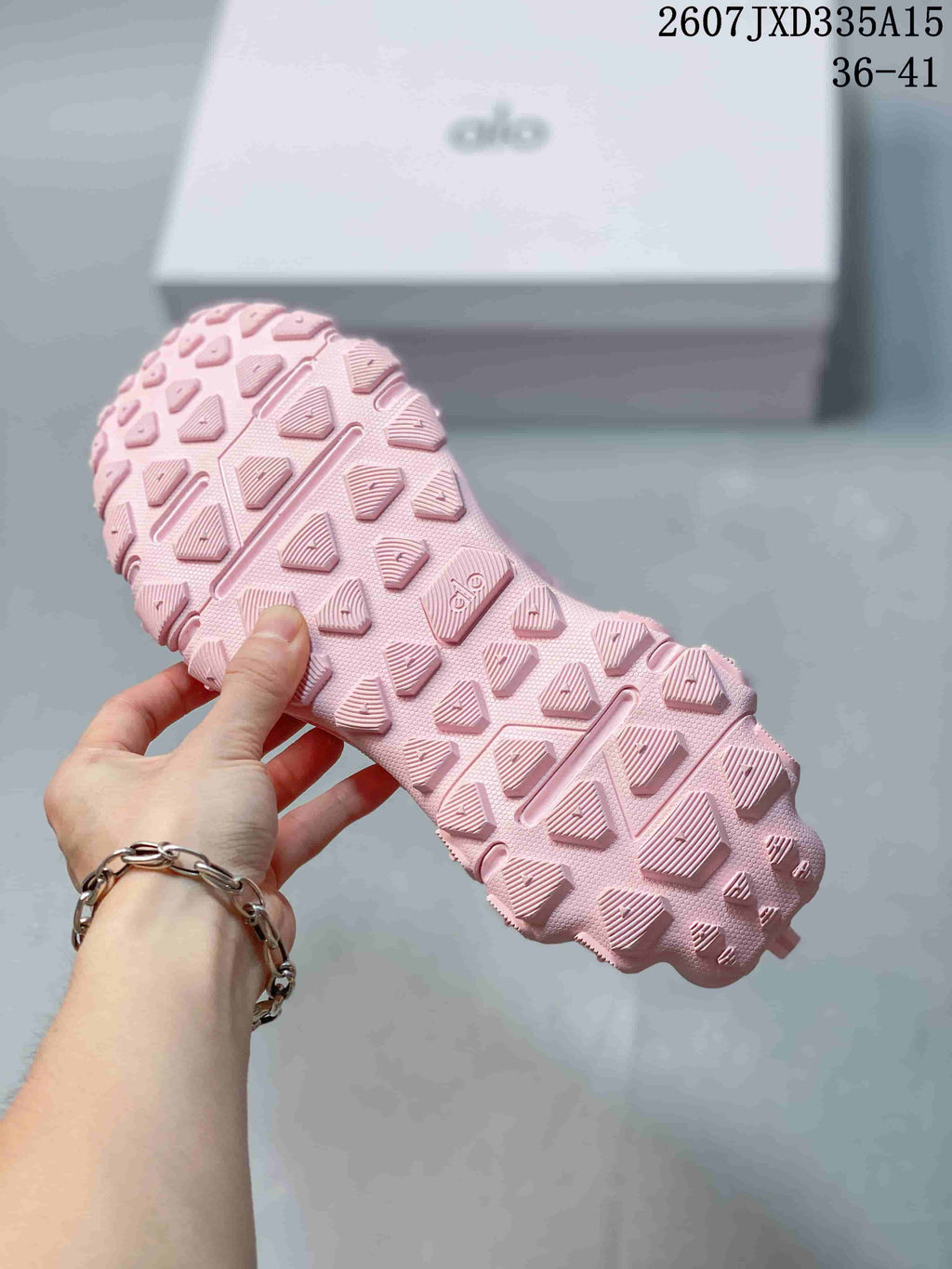 Close view of the pink sneaker outsole with a geometric lug pattern; image text shows code 2607JXD335A15 and sizes 36–41.
