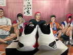 Front view of the pair, with black tongues, white uppers, red side accents, and patterned toe-side panels.