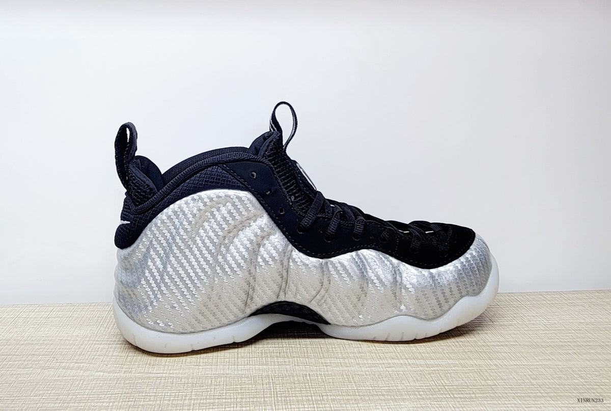 Side profile of a silver and black Nike Foamposite Pro shoe