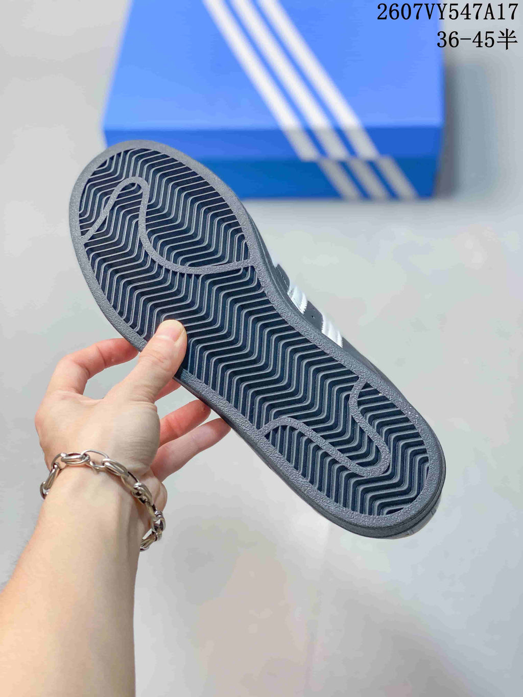 Close view of the sneaker outsole showing a dark rubber sole with a repeating zigzag tread pattern.