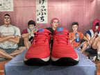 Front view of red Nike basketball shoes with mesh panels, red laces, and colored tongue details.