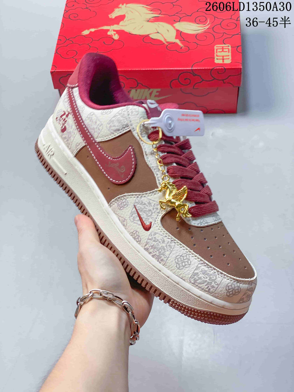 Angled view of the sneaker with patterned panels, red accents, and decorative charm