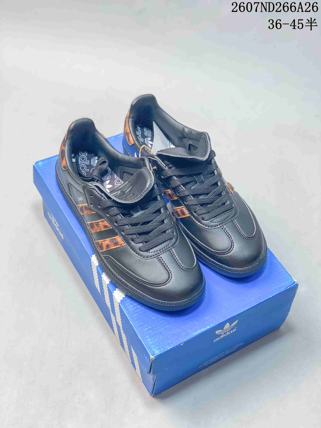 Black adidas Originals Samba OG sneakers displayed on a blue adidas shoebox, with the product code and advertised EU size range visible at the top.