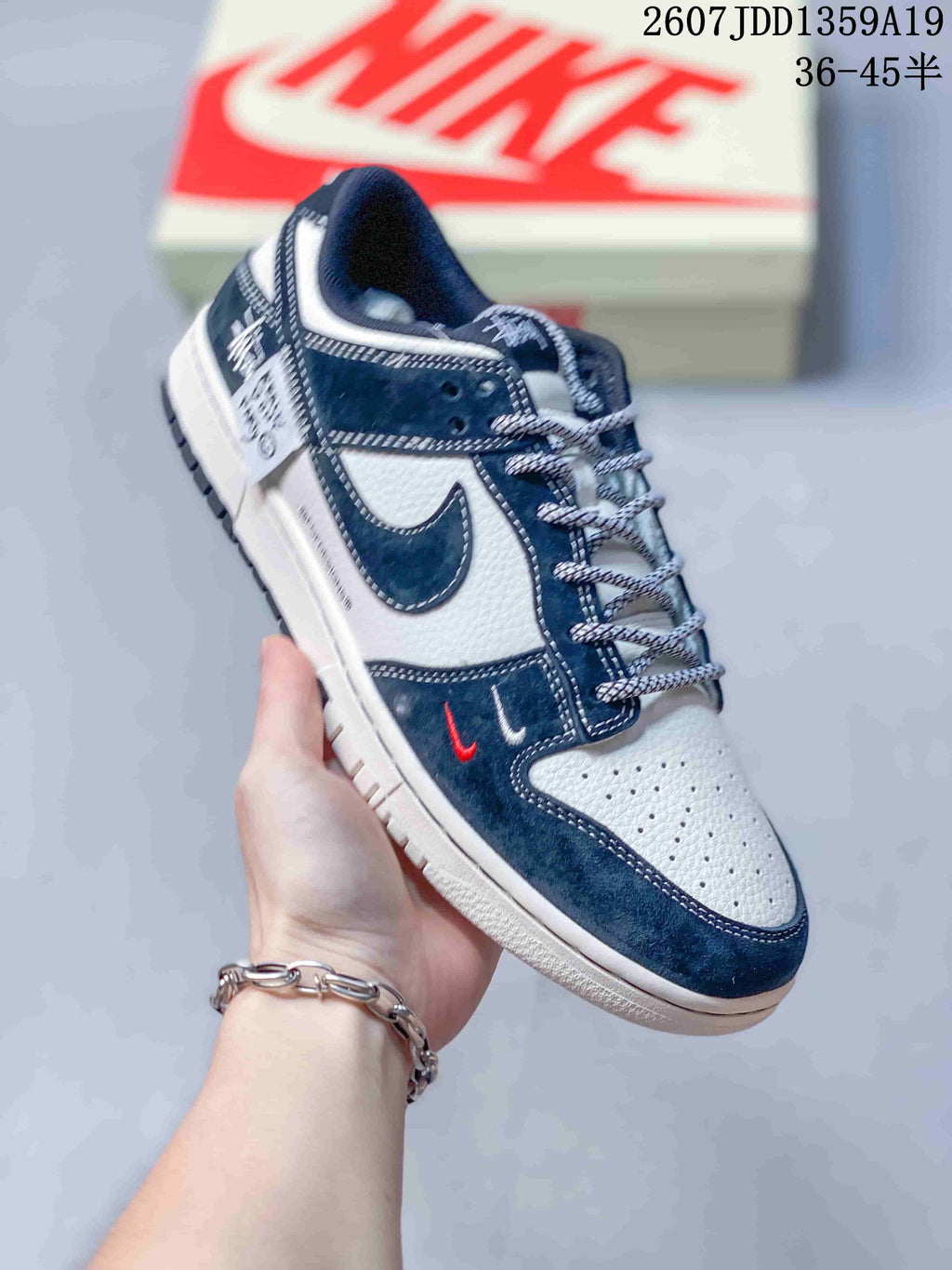 Angled side view of the navy and white low-top sneaker with contrasting outsole and heel details.