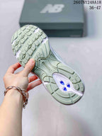 Underside view of a New Balance sneaker showing the patterned green-toned outsole and central support section.