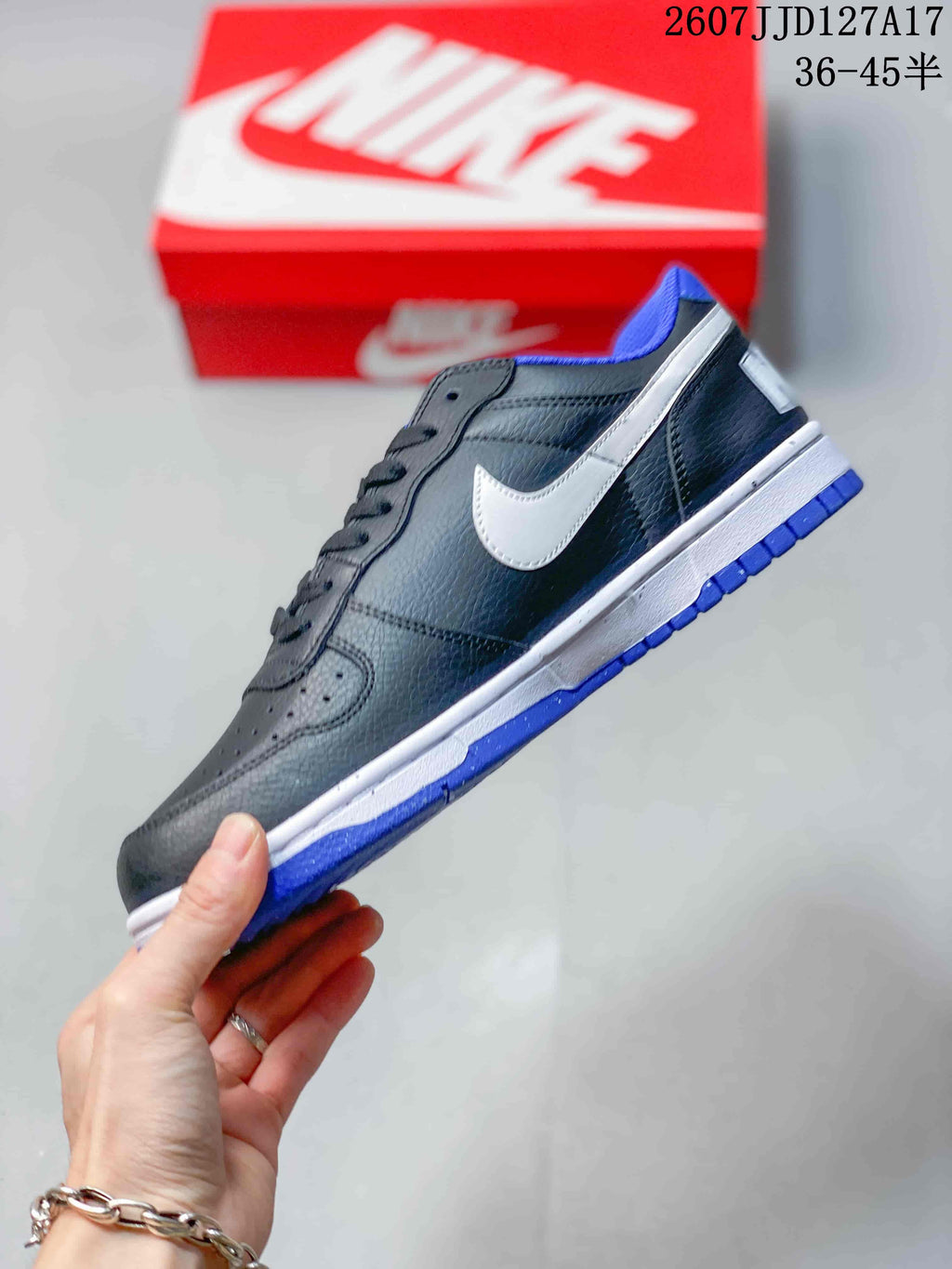 Side profile showing the black upper, white Swoosh panel, white midsole, and blue outsole.