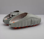 Rear three-quarter view of the gray slide sandals showing the open heels, side branding, and orange outsole elements.