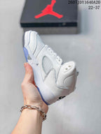 Side view of the white mid-top sneaker showing layered panels, perforated detailing, and the translucent outsole.