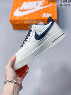Side view of the white low-top sneaker showing black Swoosh detailing, layered panels, and a textured outsole.