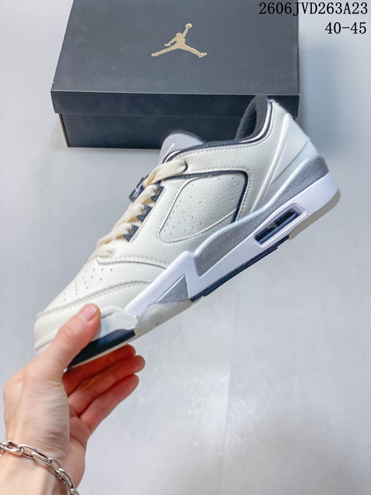Side profile of a white Jordan Sixty Plus Low with perforated panels and gray midsole accents.