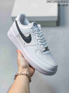 Angled side view showing the white low-top sneaker, black Swoosh, and textured outsole.