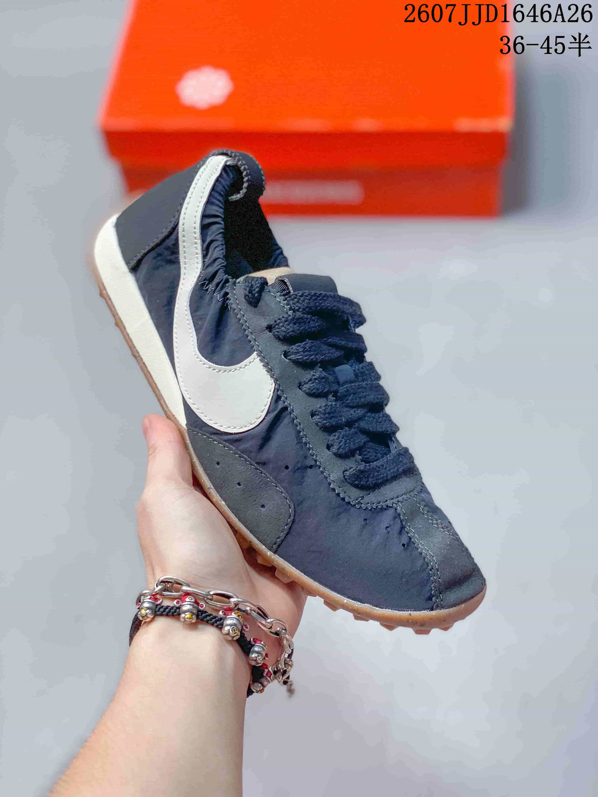Angled side view showing the white Swoosh, dark upper, lace closure, and textured gum outsole.