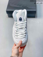 Front view of a white high-top sneaker with laces and a tongue badge.