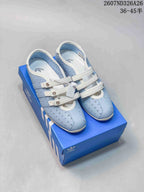 Pair of light blue Adidas Originals sneakers with white straps displayed on a blue shoebox; overlay text shows style code 2607ND326A26 and size range 36–45.5.
