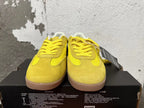 Front view of yellow lace-up Converse training-style shoes with suede-look overlays.