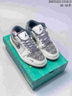 Pair of white and grey Nike SB Dunk Low sneakers with navy accents and patterned panels displayed on a green Jordan shoe box.