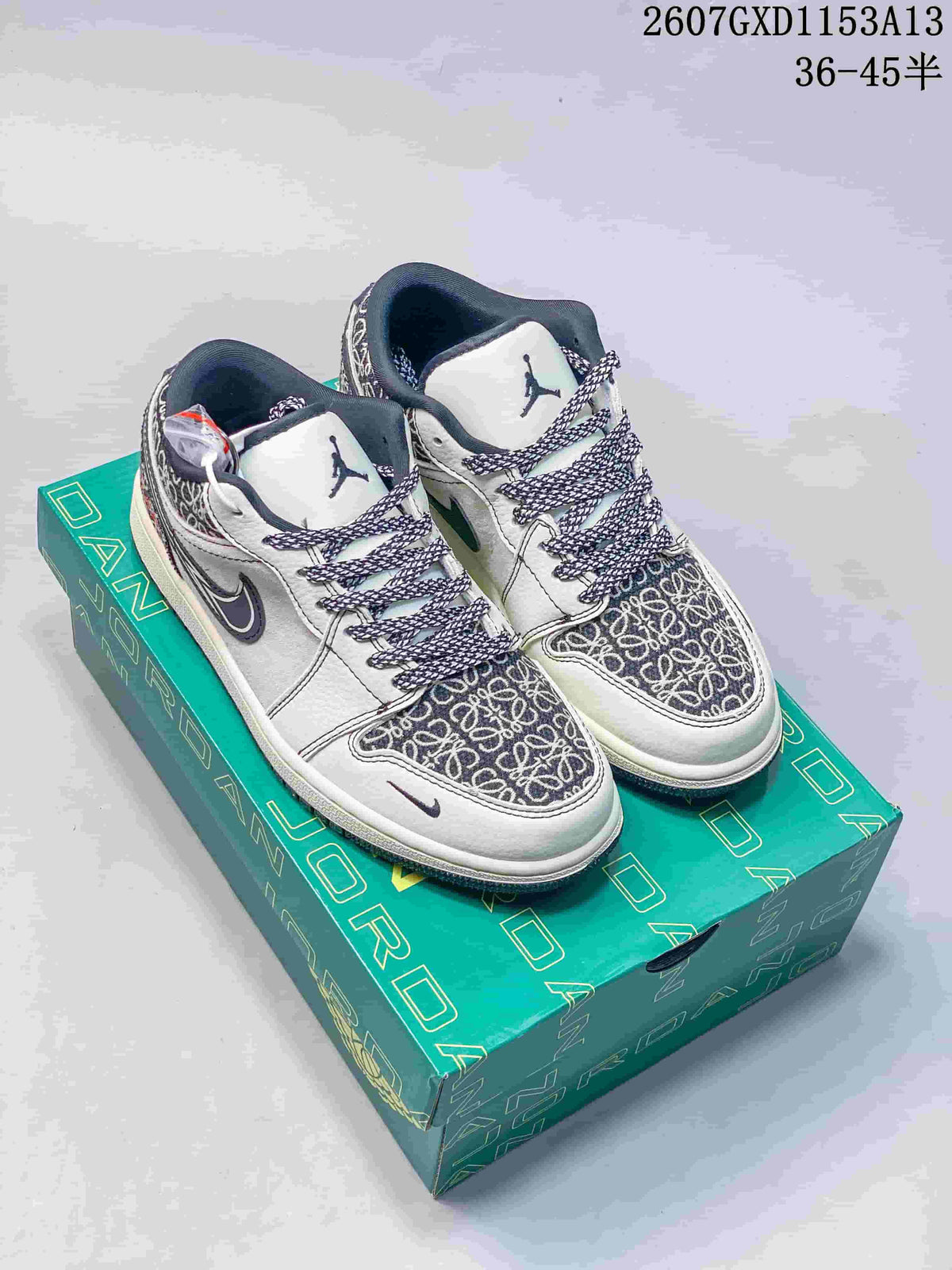 Pair of white and grey Nike SB Dunk Low sneakers with navy accents and patterned panels displayed on a green Jordan shoe box.