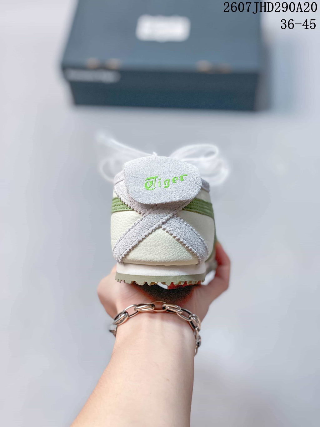 Rear view showing the Onitsuka Tiger heel branding, green stripe detail, and textured outsole edge.