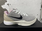 Side view of a grey patterned Nike basketball shoe with black Swoosh and Zoom midsole branding.