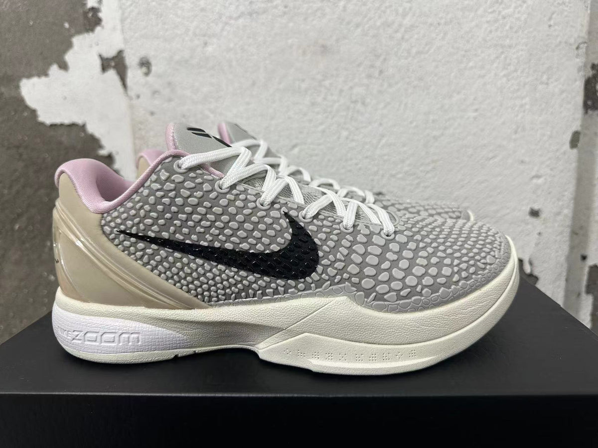 Side view of a grey patterned Nike basketball shoe with black Swoosh and Zoom midsole branding.