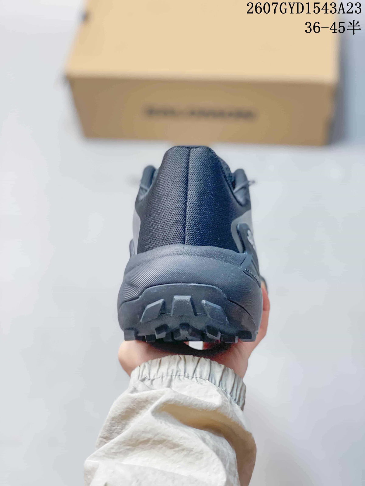 Rear view of a dark gray Salomon Genesis shoe showing the padded heel collar and lugged outsole.