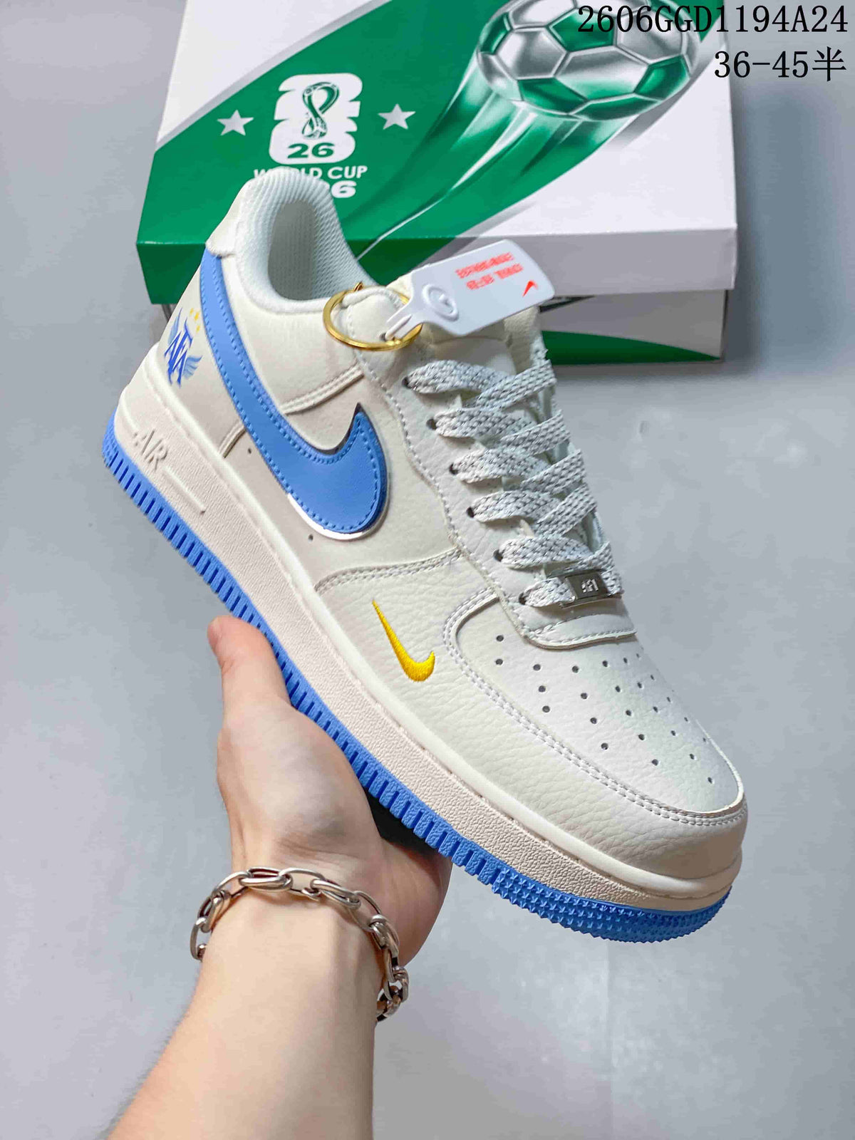 Angled view showing the white and blue sneaker, yellow accent and attached pendant.