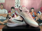 Angled view of two pink Nike sneakers displaying the black Swoosh, laces and textured white soles.