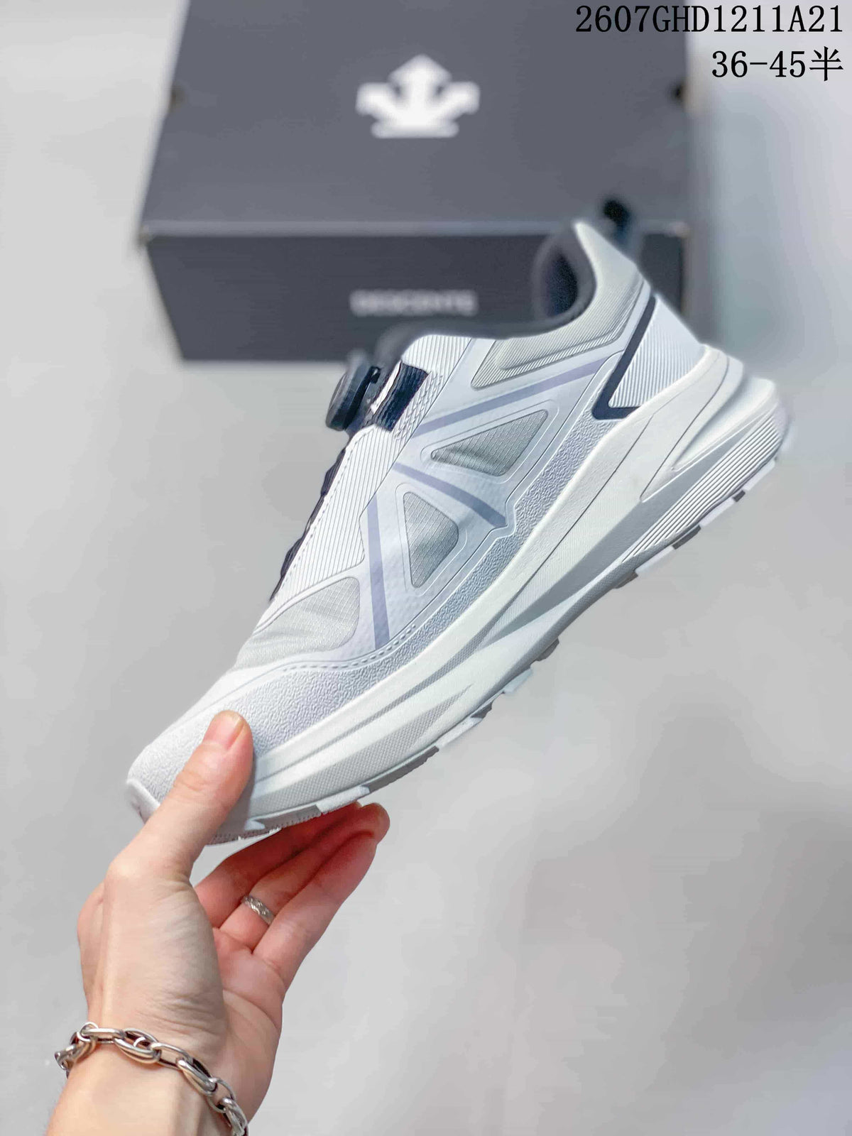 Side profile of the white and gray sneaker showing layered panels, geometric accents, and the low-top silhouette.