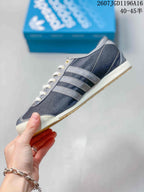 Side profile showing the dark upper, contrasting three-stripe details, light midsole, and gum outsole.