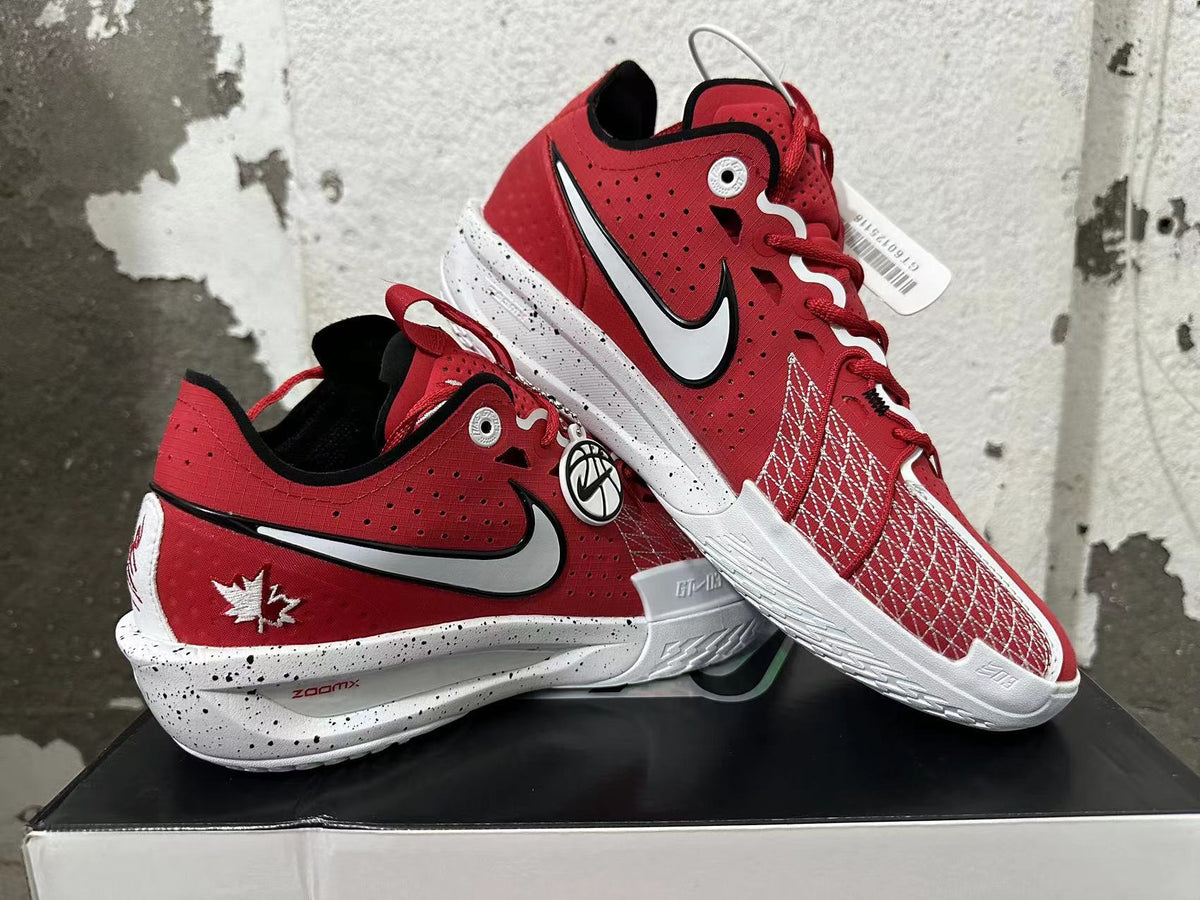 Pair of red basketball shoes displayed together, showing the Swoosh graphics, patterned panels, and maple leaf heel detail.