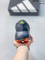 Rear view of the sneaker showing the padded heel, Adidas logo, and orange outsole accents.